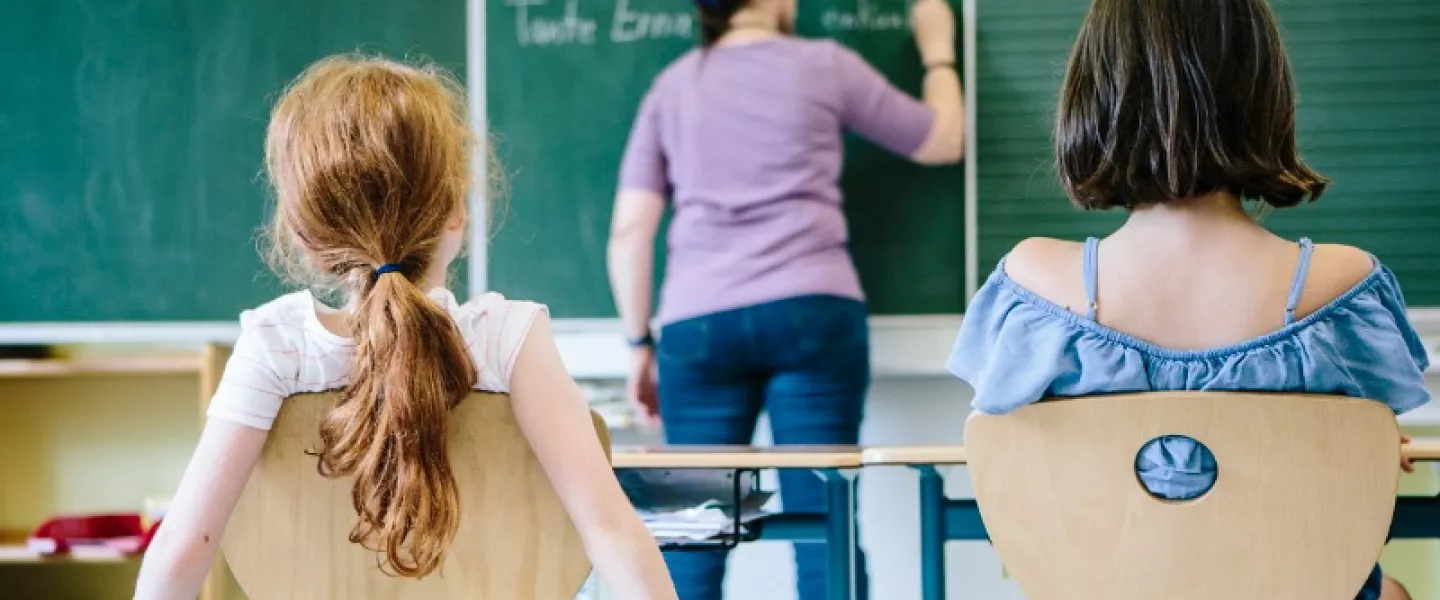 Teacher writing on blackboard