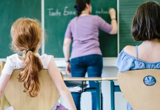 Teacher writing on blackboard