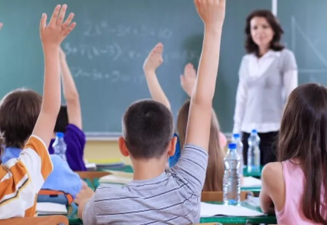 students-with-raised-hands-in-classroom.jpg